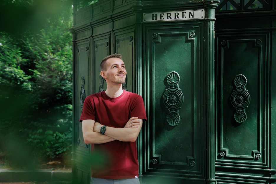 Photo of Johannes in front of a public restroom in Berlin