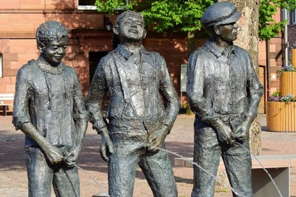 Statue mit drei Männern, die gemeinsam pinkeln